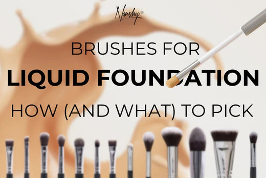 Makeup brushes arranged in a row, with a splash of liquid foundation in the background.