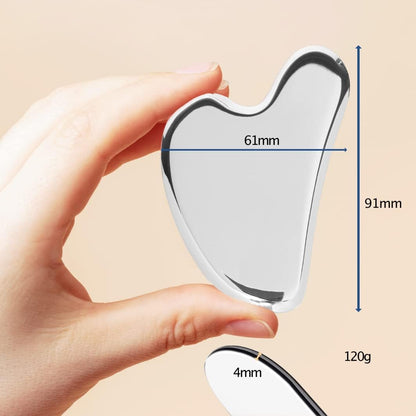 Close-up of a hand holding a stainless steel Gua Sha tool with dimensions 61mm by 91mm and 4mm thickness, weighing 120g.