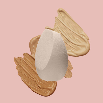 Makeup blending sponge with multi-surface design against a background of foundation smears.