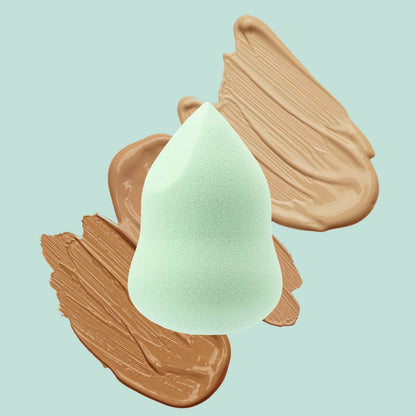 Mint green 4-in-1 Marvel Makeup Blending Sponge against foundation swatches background.