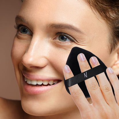 Smiling woman applying powder with a black velvet powder puff.