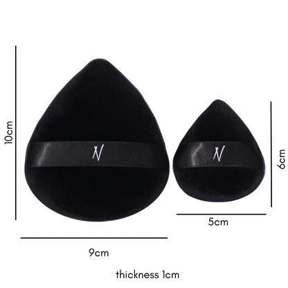 Two black velvet powder puffs, one large and one small, with an "N" logo and a black ribbon handle for easy powder application, with dimensions indicated.