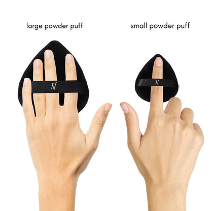 Hand demonstrating how to use the Velvet Powder Puff Duo, featuring a large powder puff on the left hand and a small powder puff on the right hand.