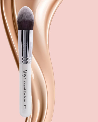 Nanshy Conceal Perfector makeup brush with soft rounded tip against a pink and beige background.