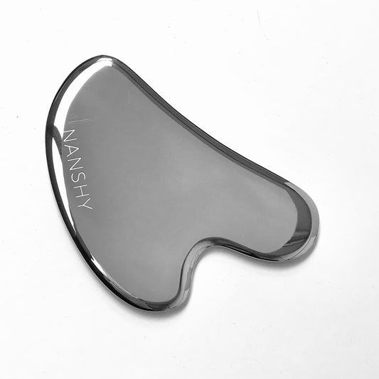 Stainless steel Gua Sha tool with smooth edges, engraved with the brand name "Nanshy."